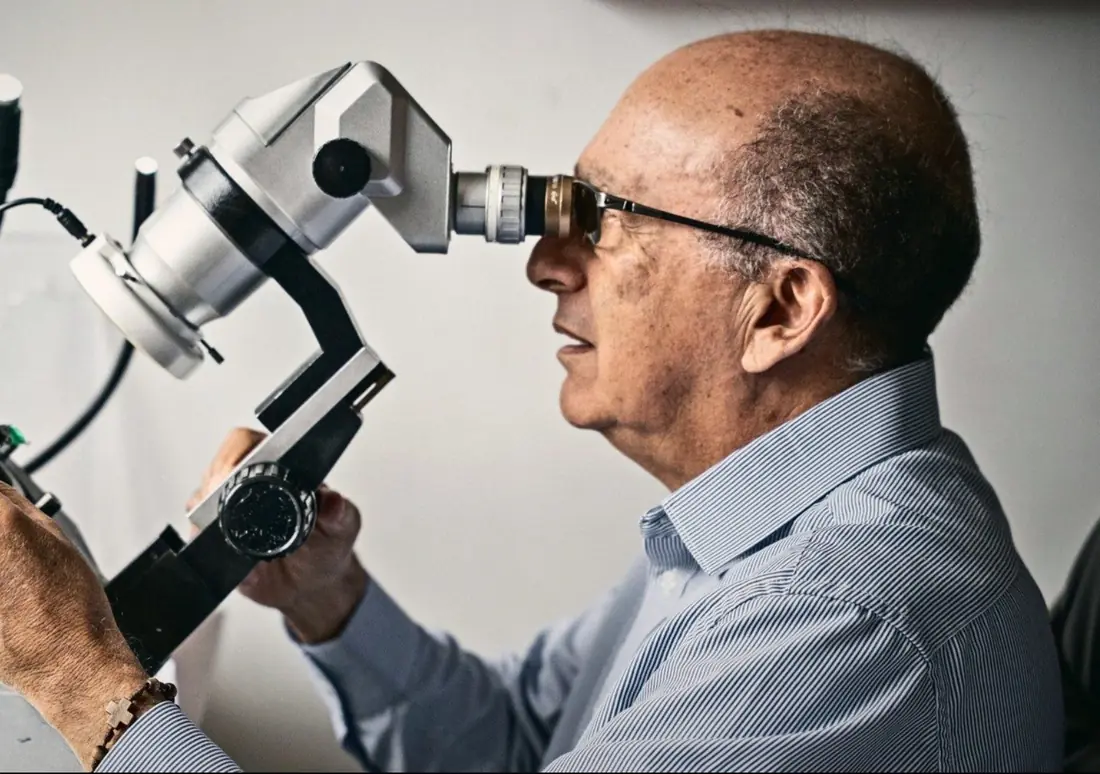 A cutter looks through a bench microscope